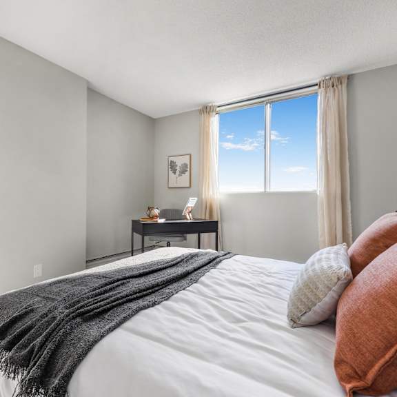 a bedroom with a large bed and a window overlooking the sky.