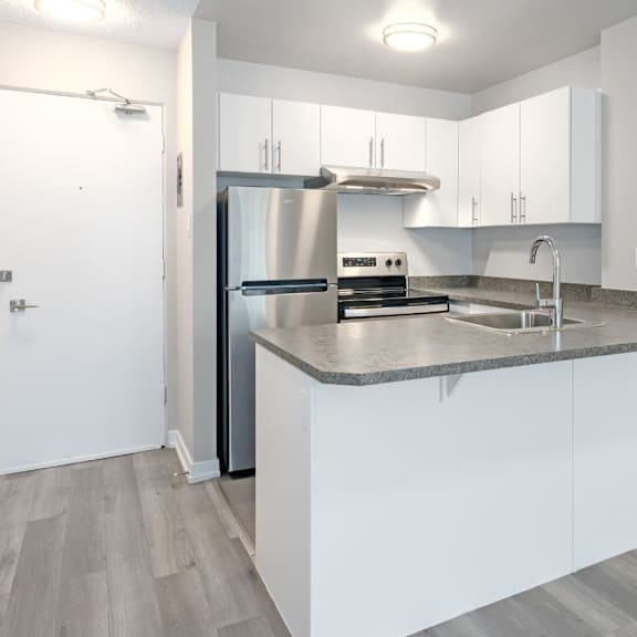 a modern kitchen with white cabinets and a stainless steel refrigerator.