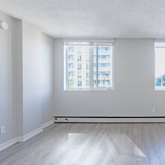a large empty room with a window overlooking a cityscape.