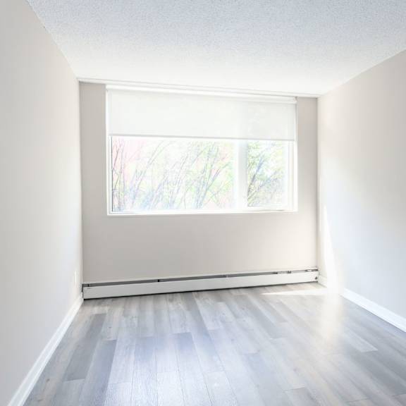 a room with a window and wooden flooring.