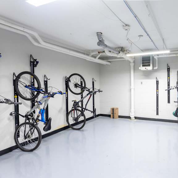 a bike repair shop with bikes on the wall and floor.