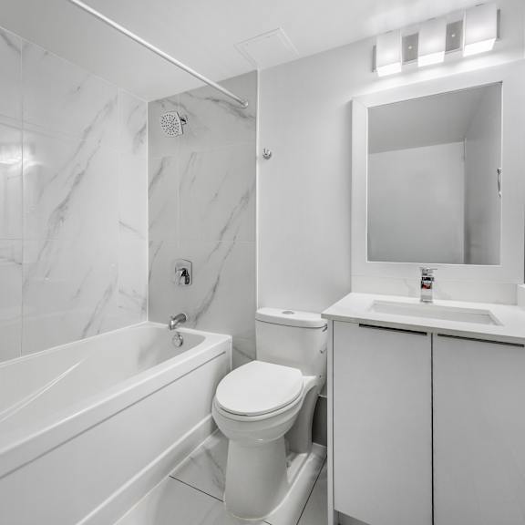 a white bathroom with a tub, toilet, and sink.