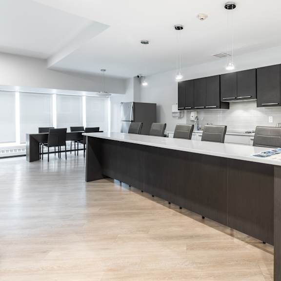 a modern kitchen with a long island and black cabinets.
