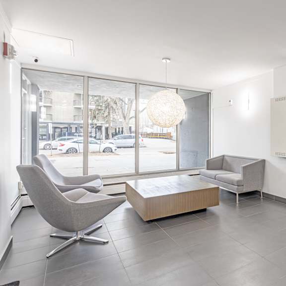 a modern living room with a grey chair and a white sofa.