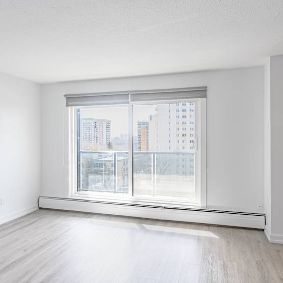 a large empty room with a window overlooking a cityscape.