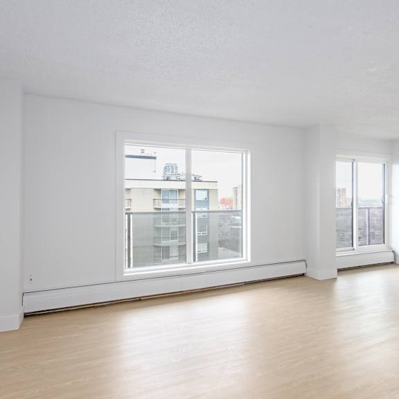 a large empty room with a window overlooking a cityscape.
