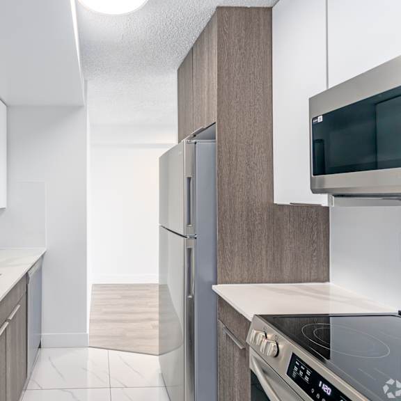a modern kitchen with a stainless steel oven and white countertops.