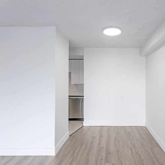 a white room with a wooden floor and a light on the ceiling.