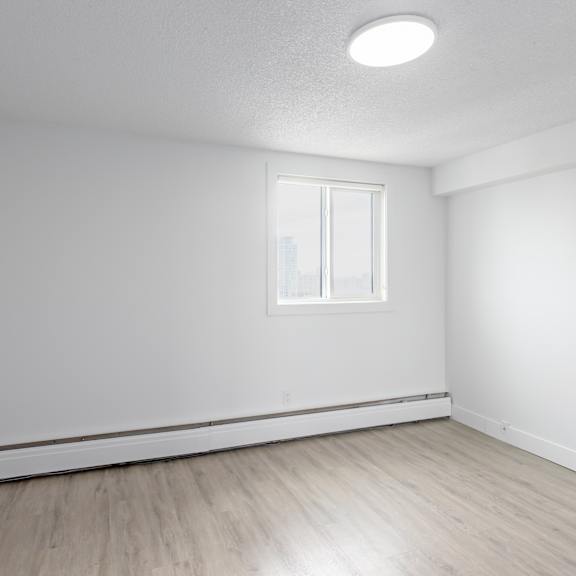 a room with a window and wooden flooring.