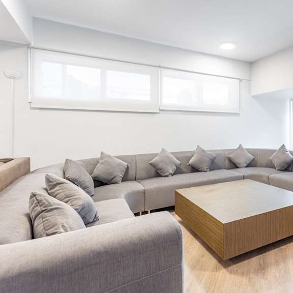 a modern living room with a grey sofa and a wooden coffee table.