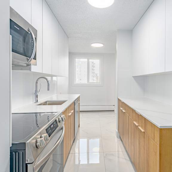 a modern kitchen with stainless steel appliances and wooden cabinets.