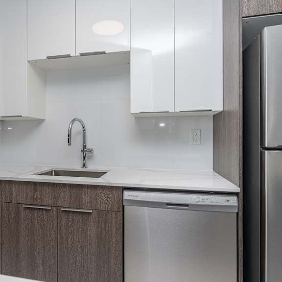 a modern kitchen with a stainless steel dishwasher and white cabinets.