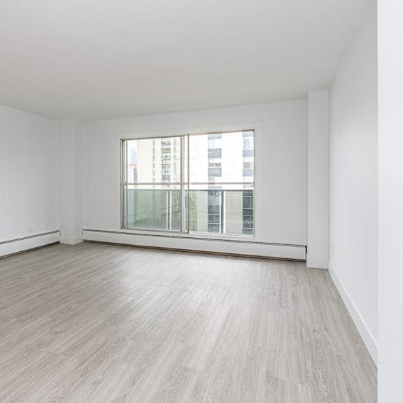 a room with a window and wooden flooring.