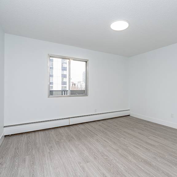 a room with a window and wooden flooring.