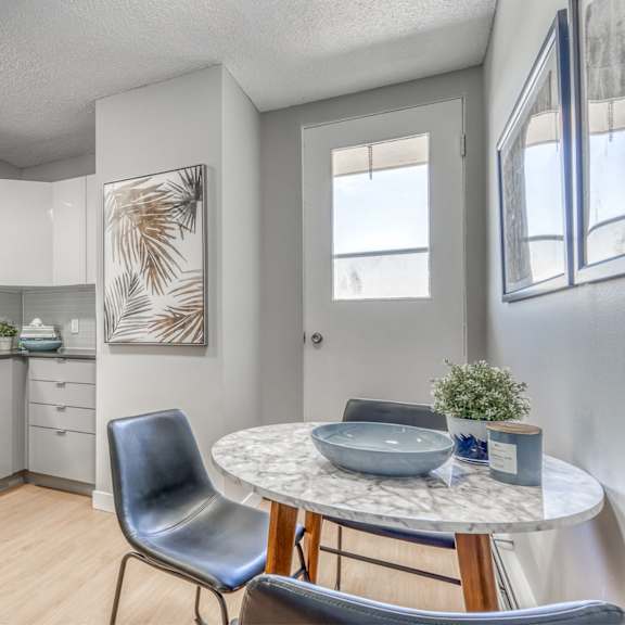 a modern kitchen with a dining table and chairs.