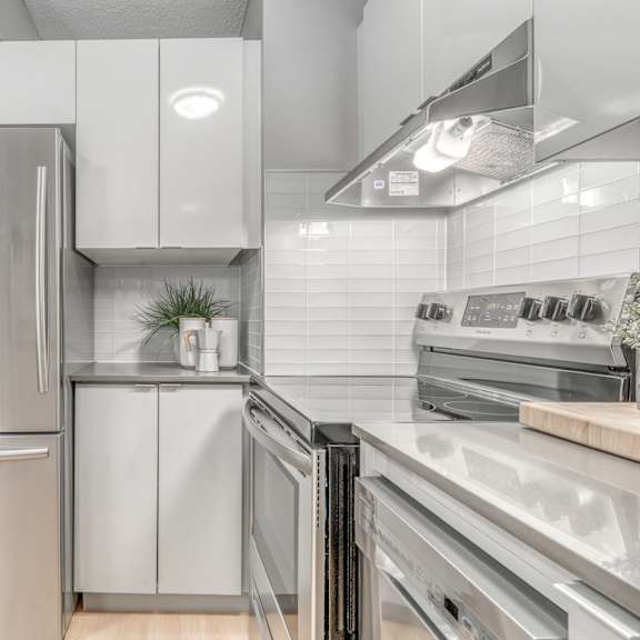 a modern kitchen with a stainless steel refrigerator and a range hood.