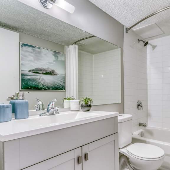 a white bathroom with a white tub and toilet.