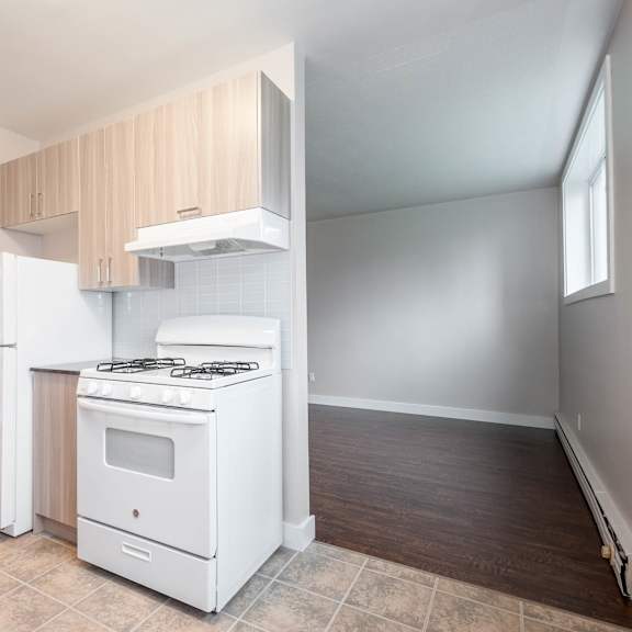 a kitchen with white appliances and wooden cabinets.