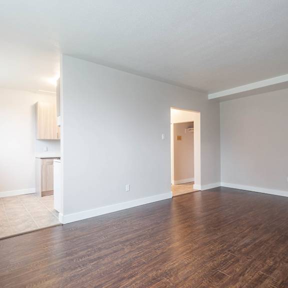 a large empty room with wooden floors and white walls.