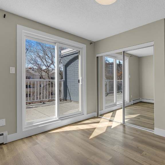 a room with a sliding glass door leading to a balcony.