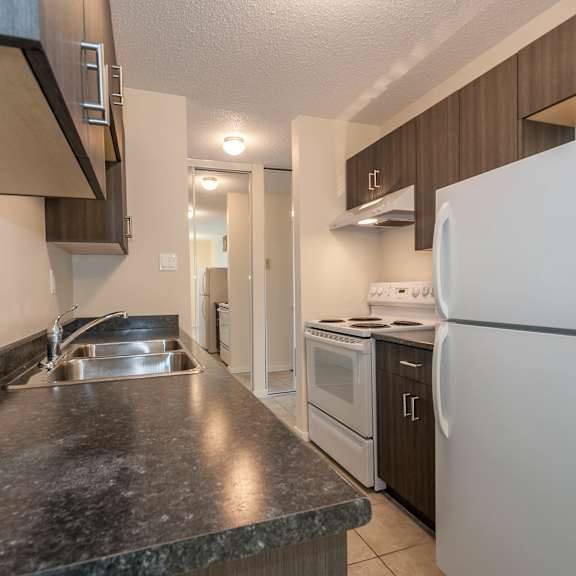 a kitchen with a sink, stove, and refrigerator.