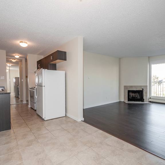 a kitchen with a refrigerator, sink, and cabinets.