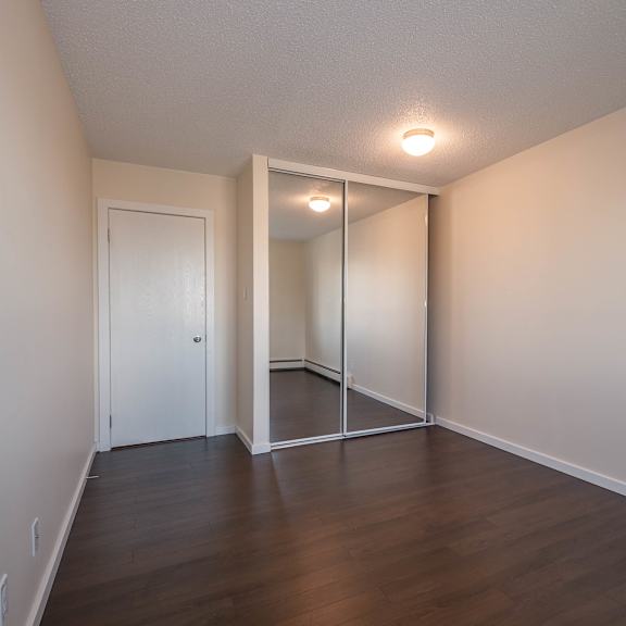 a room with a white door and a mirror on the wall.