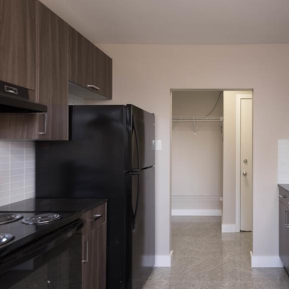 a kitchen with black appliances and brown cabinets.