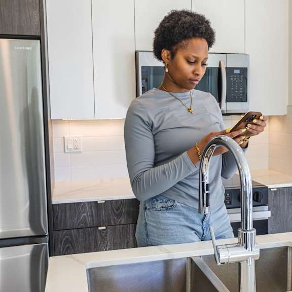 a woman is washing dishes in a modern kitchen.