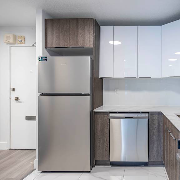 a modern kitchen with a stainless steel refrigerator and a dishwasher.