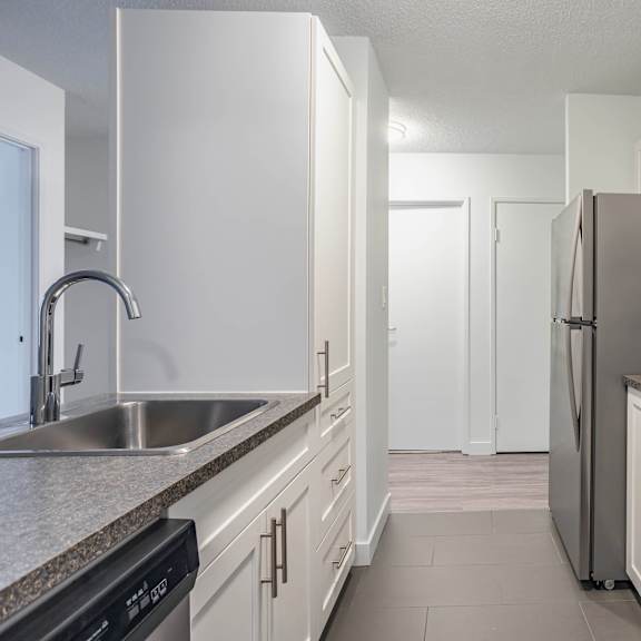 a kitchen with white cabinets and stainless steel appliances.
