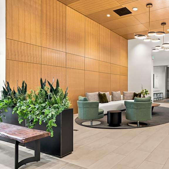 a modern office lobby with a wooden wall and a green plant.