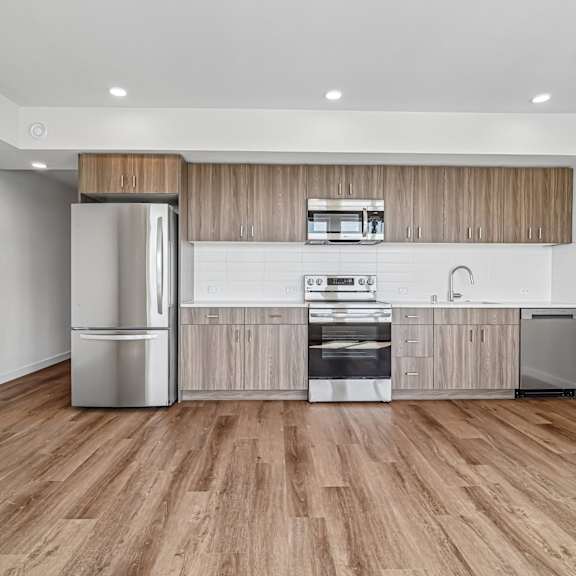 a modern kitchen with wooden cabinets and stainless steel appliances.