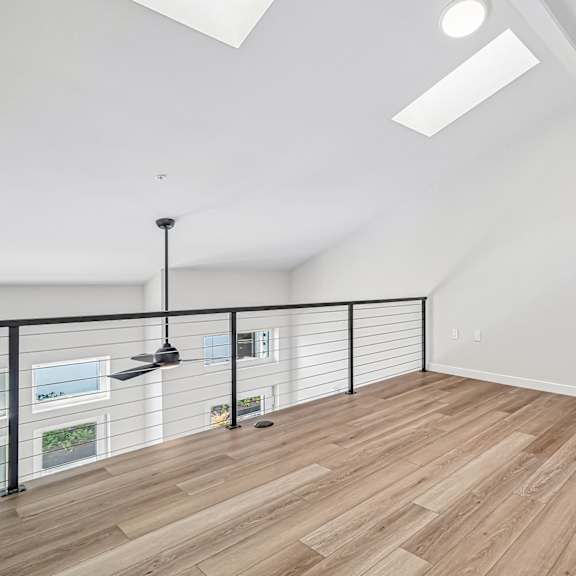 a room with wooden flooring and a black metal railing.
