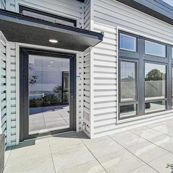 a modern house with a grey exterior and a glass door.