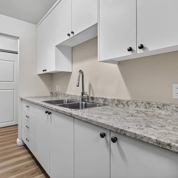 a kitchen with white cabinets and a granite countertop.