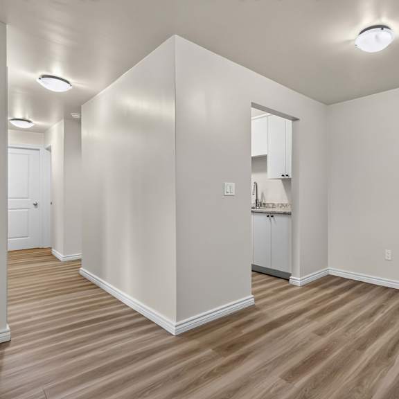 a room with wooden flooring and white walls.