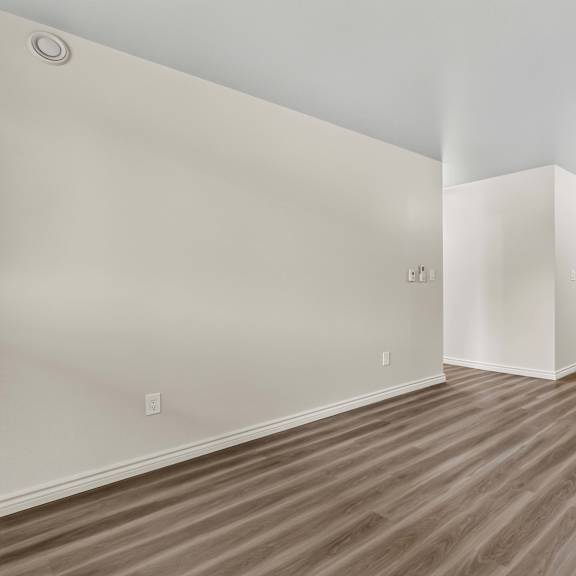 a room with wooden flooring and white walls.