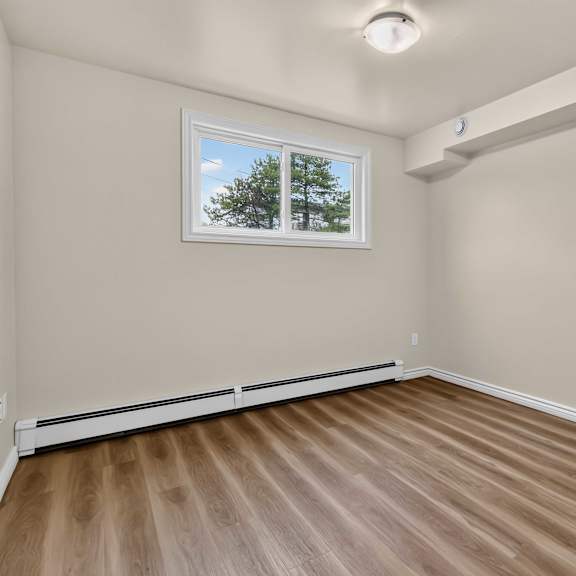 a room with a window and wooden flooring.