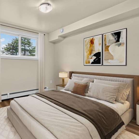 a well-lit bedroom with a large bed and a potted plant.