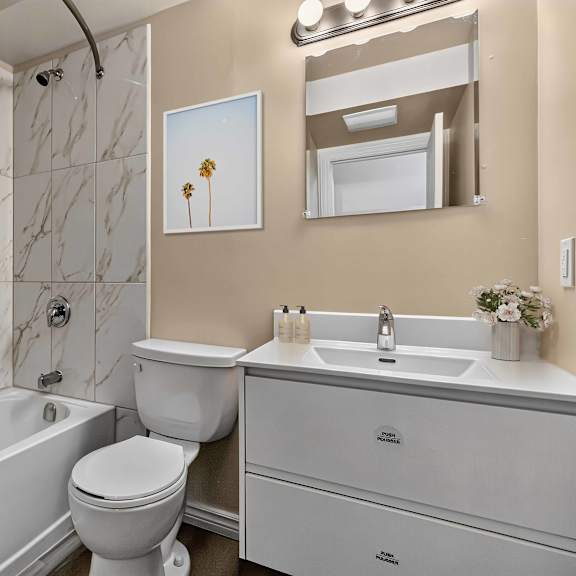 a bathroom with a white tub, toilet, and sink.