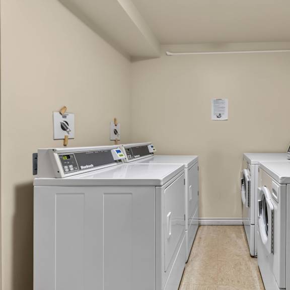two washing machines in a small room.