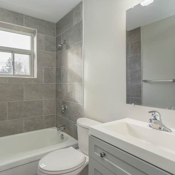 a white toilet sits next to a bathtub in a bathroom.