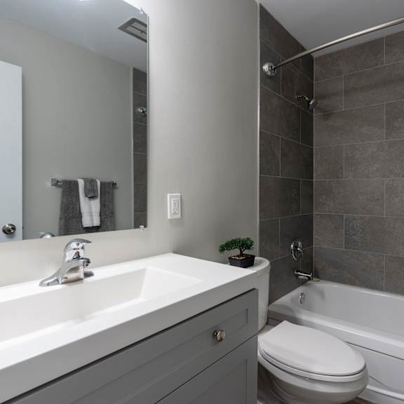 a bathroom with a white sink, toilet, and bathtub.