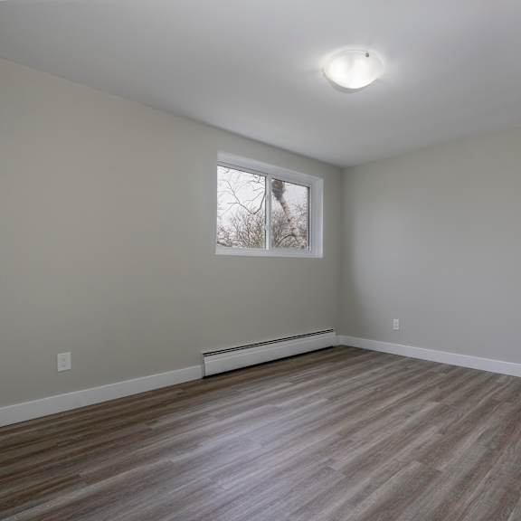 a room with a window and wooden flooring.