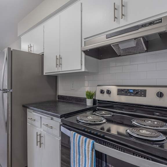 a kitchen with a black stove top oven and a black counter top.