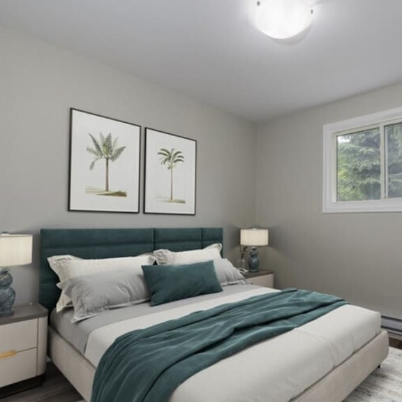 a bedroom with a bed, two lamps, and two framed pictures on the wall.
