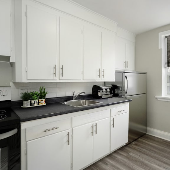 a kitchen with white cabinets and a black stove top.