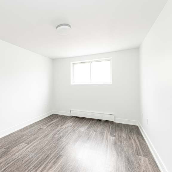 a room with a window and wooden flooring.