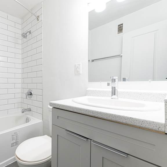 a white bathroom with a tub, toilet and sink.